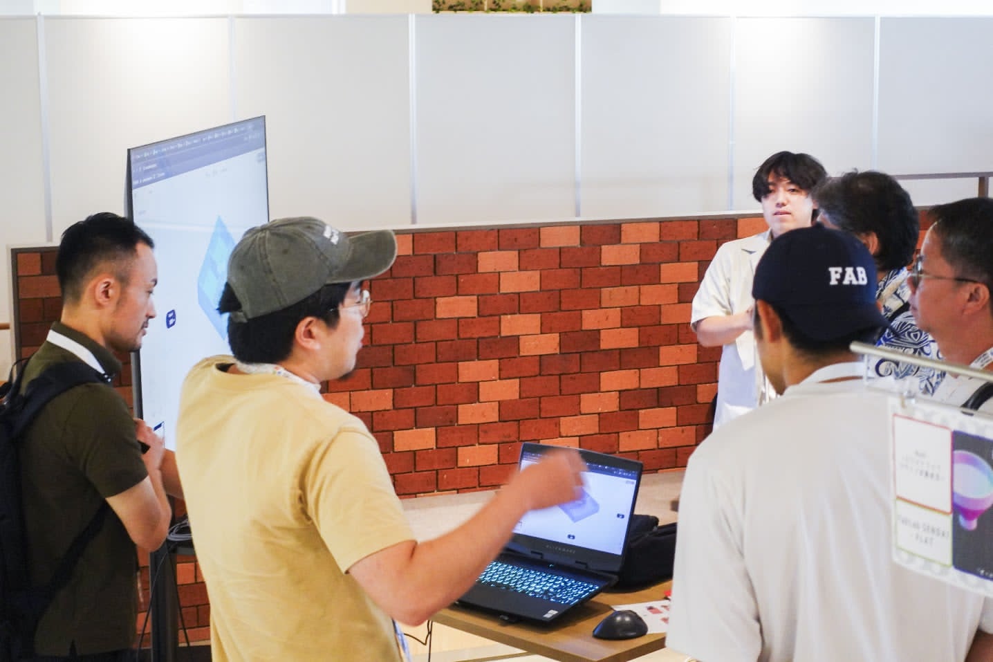 Participants gather around a laptop to discuss a model created in Nodi